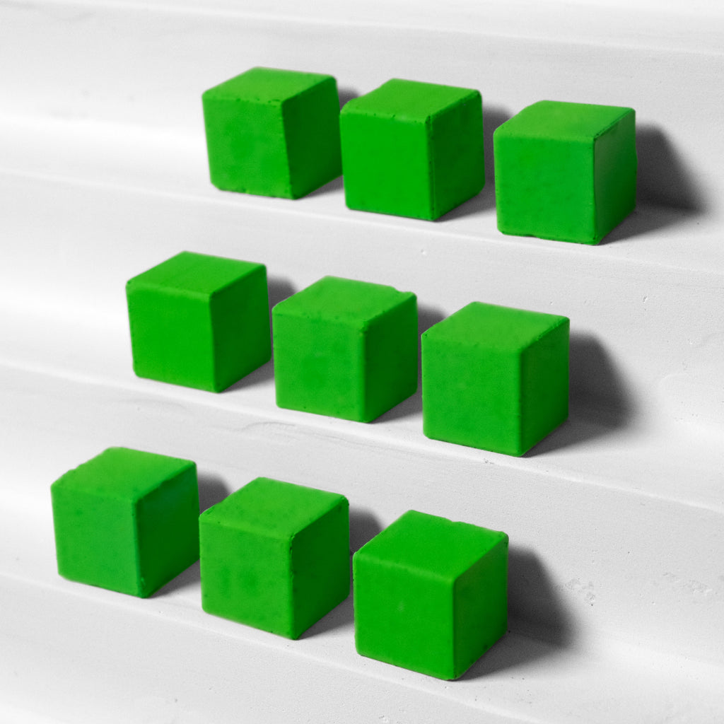 Green cubes arranged on a white surface