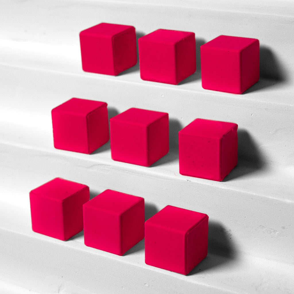 Nine pink cubes arranged in a 3x3 grid on a light gray surface.