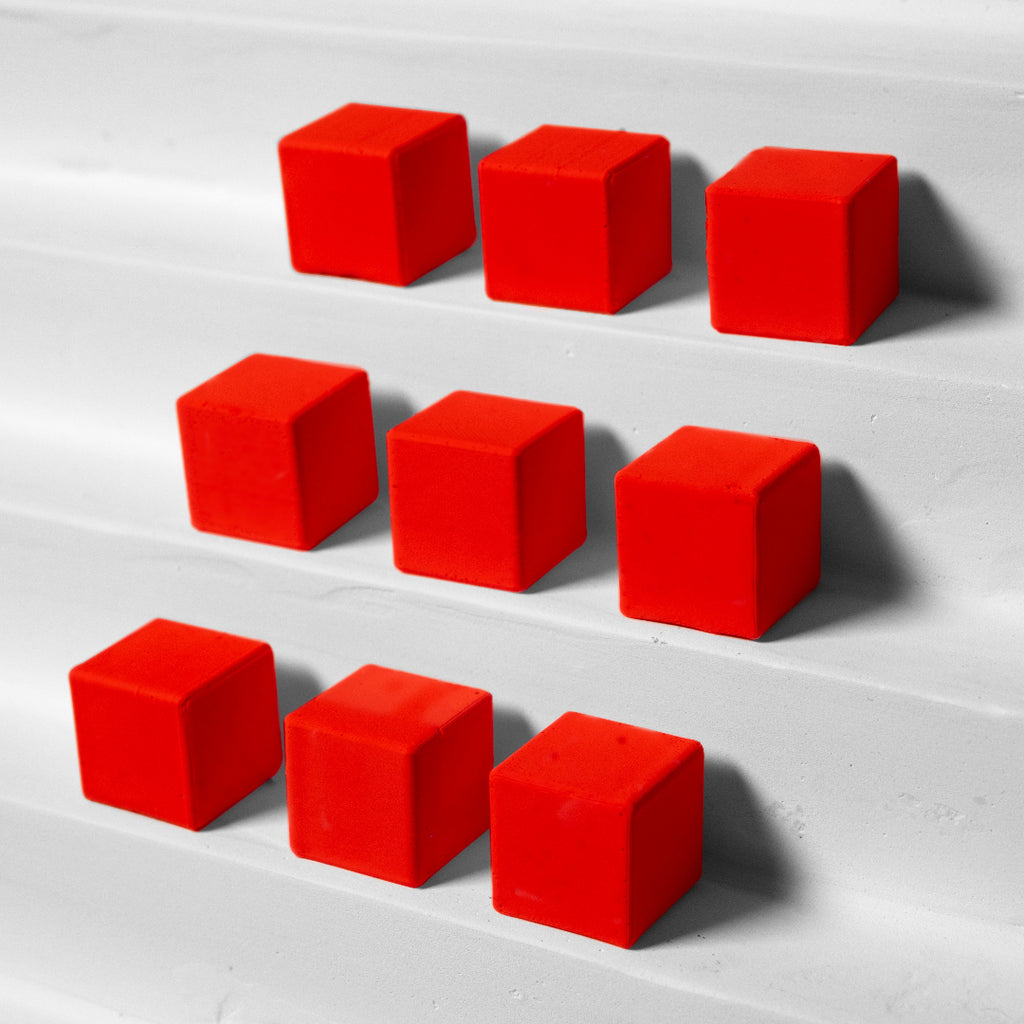 Red cubes arranged in a pattern on a white surface