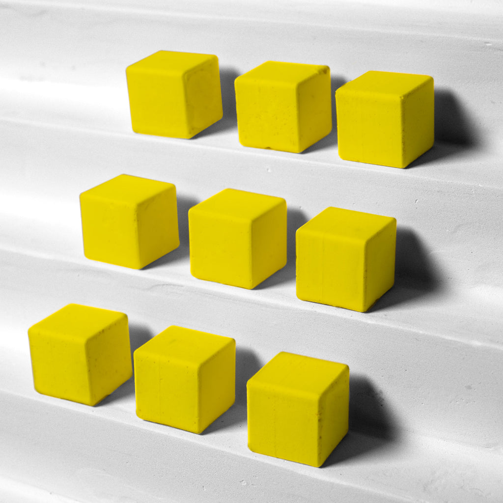 Yellow cubes arranged in a pattern on a white surface